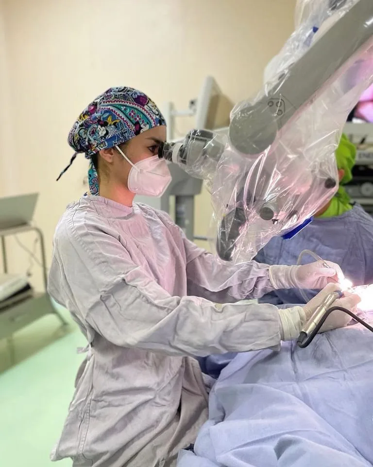 Dra. Estefana Rangel operando con microscopio quirúrgico